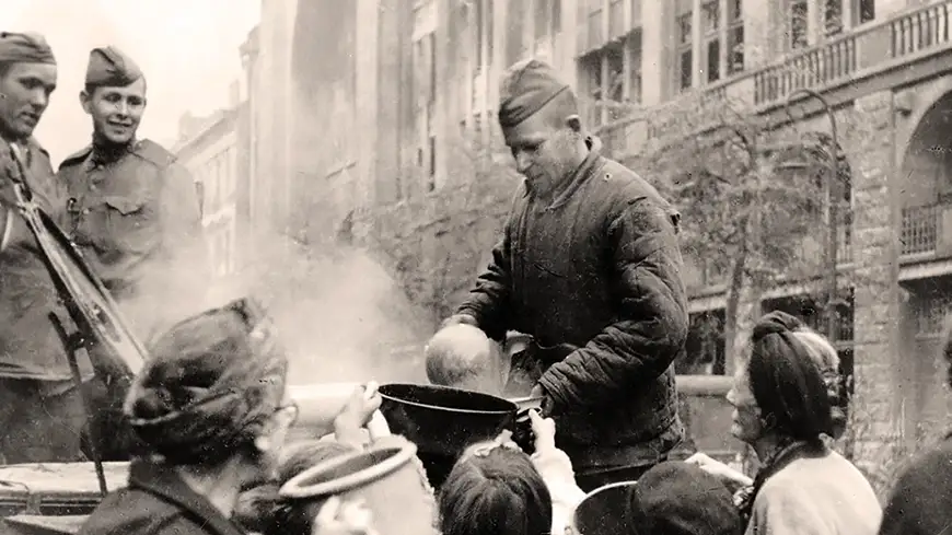 советский солдат кормит кашей немцев